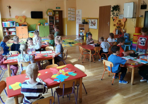 Przedszkolak tworzy pracę plastyczną na temat „Moje przedszkole”, wykorzystując materiały plastyczne.