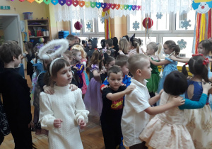 dzieci w strojach karnawałowych tańczą do wesołej muzyki