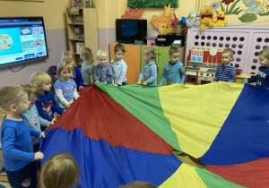 zabawa przedszkolaków z kolorową chustą animacyjną