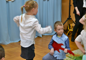 chłopiec gra na gitarze, dziewczynka tańczy