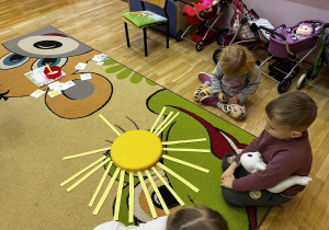przedszkolaki układają na dywanie słoneczka