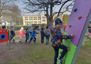 dzieci korzystają z urządzeń rekreacyjnych znajdujących się w przedszkolnym ogrodzie