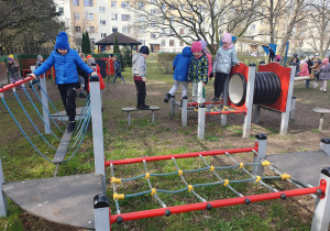 dzieci korzystają z urządzeń rekreacyjnych znajdujących się w przedszkolnym ogrodzie