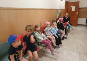 dzieci siedzą na poczekalni w przychodni