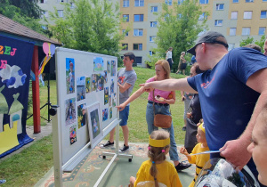 rodzice oglądają wystawę prac fotograficznych