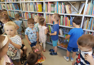 dzieci oglądają księgozbiór biblioteki