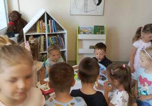 dzieci siedzą w czytelni miejskiej biblioteki