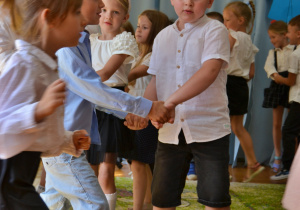 przedszkolaki tanczą, trzymają sie za dłonie