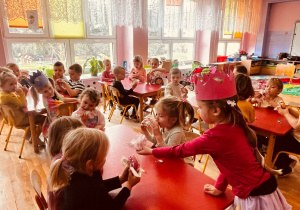 dziewczynka częstuje dzieci pączkami