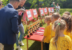 panowie wręczają dzieciom medale
