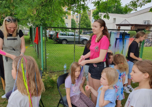 Dziewczynki z kolorowymi warkoczykami pozują do zdjęcia – każda fryzura inna, ale każda wyjątkowa