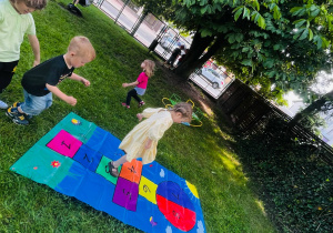 dzieci skacza na kolorowych matach