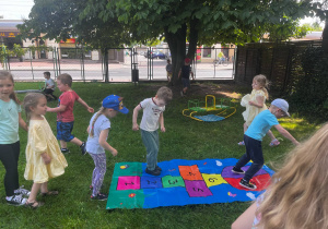 dzieci skacza na kolorowych matach