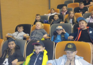 dzieci siedzą na widowni w teatrze