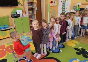 urodziny obchodził Kacperek, dzieci częstują ustawione w rzędzie częstują się upominkami