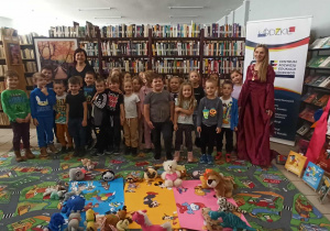 zdjęcie dzieci wśród księgozbioru biblioteki