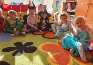 Na zdjęciach widać roześmiane dzieci przebrane za swoich ulubionych bohaterów, siedzą na dywanie