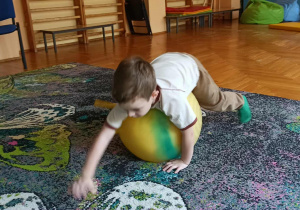 dziecko turla się na piłce