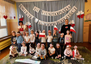 zdjęcie ukazuje grupę II – dzieci z dumą trzymają w dłoniach flagi w barwach narodowych. Na twarzach widać radość i powagę, a w powietrzu unosi się prawdziwie patriotyczna atmosfera.