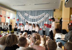 Recytacja patriotycznych wierszy – na zdjęciu widać grupę dzieci stojących w półkolu. Z przejęciem i zaangażowaniem mówią wiersze o wolności, ojczyźnie i bohaterstwie.