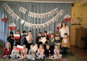 zdjęcie ukazuje wspólny grupy III – dzieci z dumą trzymają w dłoniach flagi w barwach narodowych.