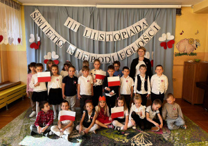 zdjęcie ukazuje wspólny grupy VI – dzieci z dumą trzymają w dłoniach flagi w barwach narodowych. Na twarzach widać radość i powagę, a w powietrzu unosi się prawdziwie patriotyczna atmosfera.