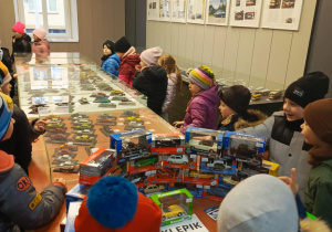 dzieci oglądają wystawę modeli samochodowów