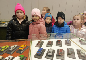 dzieci oglądają wystawę modeli samochodowów
