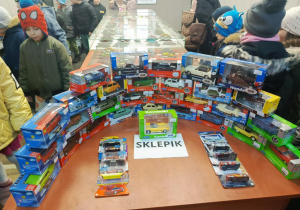 dzieci oglądają wystawę modeli samochodowów