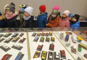 dzieci oglądają wystawę modeli samochodowów