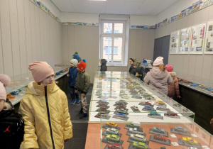 dzieci oglądają wystawę modeli samochodowów
