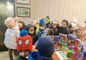 dzieci oglądają wystawę modeli samochodowów