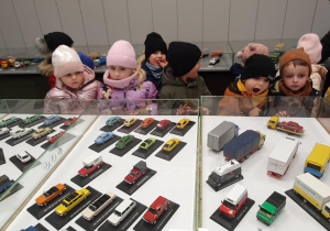 dzieci oglądają wystawę modeli samochodowów