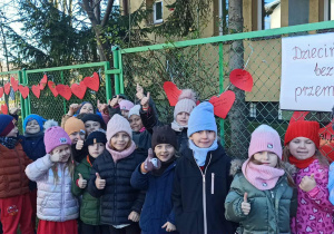 przedszkolaki przed budynkiem przedszkola, z tyłu widać czerwone serca