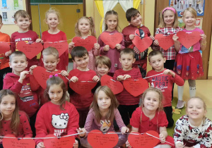 dzieci prezentują czerwone serca