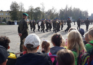 jednostka wojskowa, dzieci obserwują grajacą orkiestrę wojskową