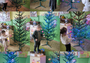 dzieci dekorują choinkę w sali przedszkolnej