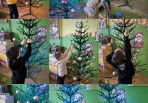 dzieci dekorują choinkę w sali przedszkolnej