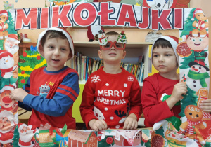 dzieci pozują zdjęcia z ramka z napisem Mikołajki
