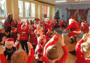 Fotografia przedstawia moment wspólnego tańca i zabaw przy muzyce dzieci i Mikołaja