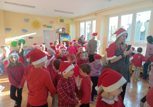 Fotografia przedstawia moment wspólnego tańca i zabaw przy muzyce dzieci i Mikołaja