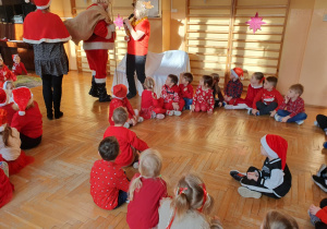 Na zdjęciu widać Mikołaja wchodzącego z workiem pełnym prezentów.