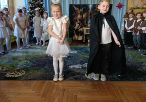 Na zdjęciu widać dzieci z najstarszej grupy przedszkolnej stojące na scenie i recytujące swoje kwestie podczas jasełek.