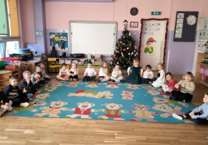 dzieci siedza na dywanie