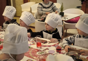 Przedszkolaki z dużym zainteresowaniem słuchają opowieści prowadzących o procesie powstawania czekolady oraz z uwagą obserwują prezentowane materiały i akcesoria cukiernicze.