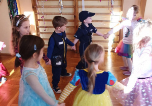 dzieci tańcza trzymajac sie za rece