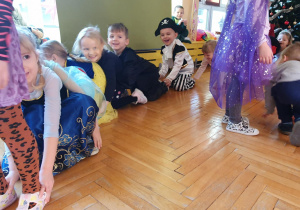 dzieci tańczą trzymając się za stopy