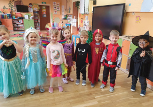 dzieci w strojach karnawałowych pozuja do zdjęcia