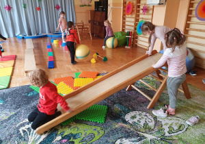 Przedszkolaki wspinają się i skaczą.