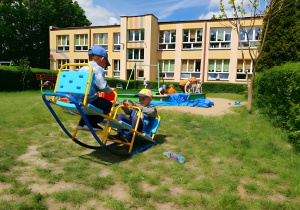 Na zdjęciu widoczne są przedszkolaki korzystające z ogrodu dydaktycznego. Dzieci aktywnie uczestniczą w zabawie piaskiem, tworząc różnorodne formy i konstrukcje, co dostarcza im wiele radości i satysfakcji.